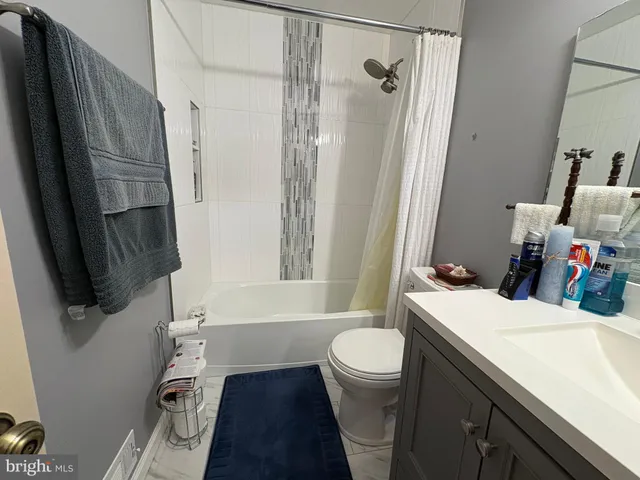 a bathroom with a sink a toilet a tub and shower