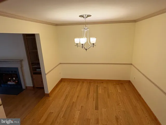 a view of a room with wooden floor a fireplace and windows