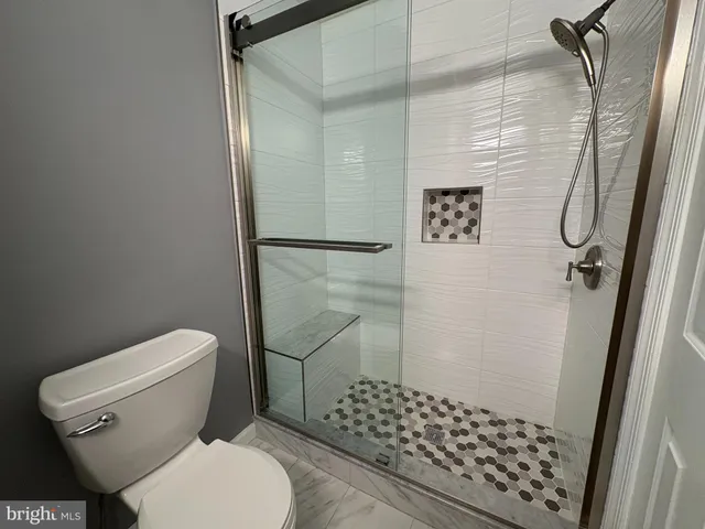 a bathroom with a toilet and a shower