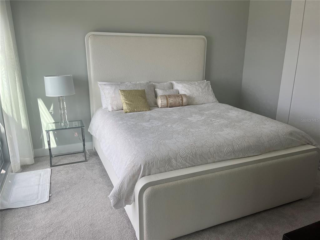 301 Quay Commons, Unit 1808 Sarasota, FL 34236 - Photo 12 of 12 a bed sitting in a bedroom next to a lamp