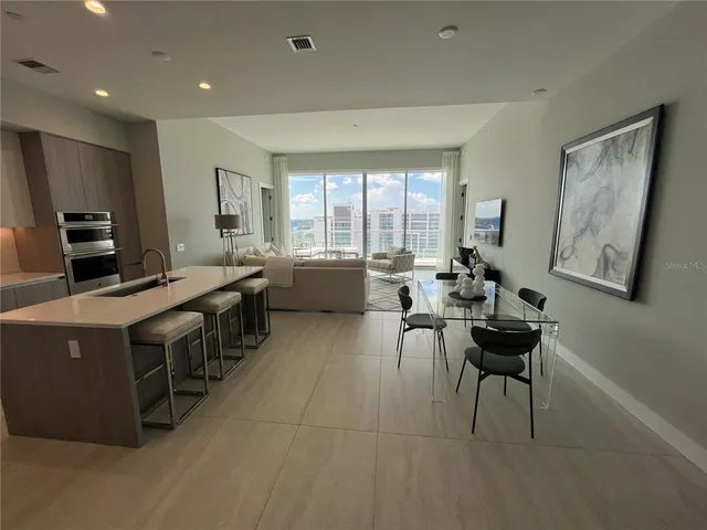 a kitchen with kitchen island granite countertop a sink counter top space appliances and a large window