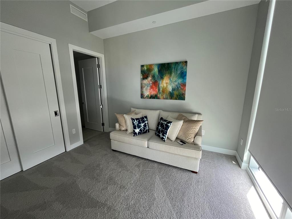 301 Quay Commons, Unit 1808 Sarasota, FL 34236 - Photo 10 of 12 a living room with furniture and a flat screen tv