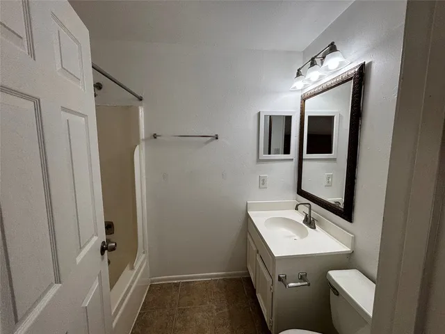 a bathroom with a sink and mirror with toilet