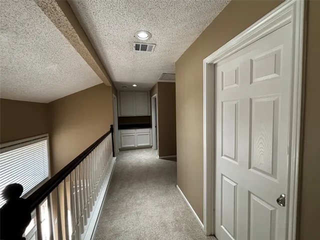 a view of a hallway with wooden floor and stairs