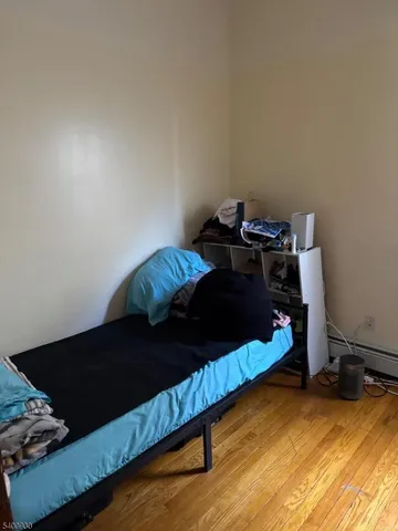 a bedroom with a bed and a wooden floor