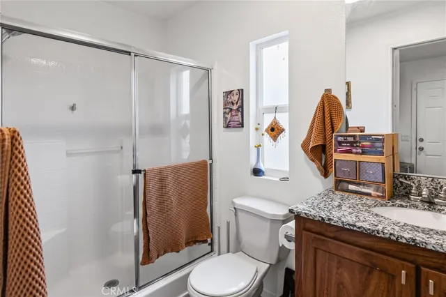 a bathroom with a granite countertop sink toilet and shower