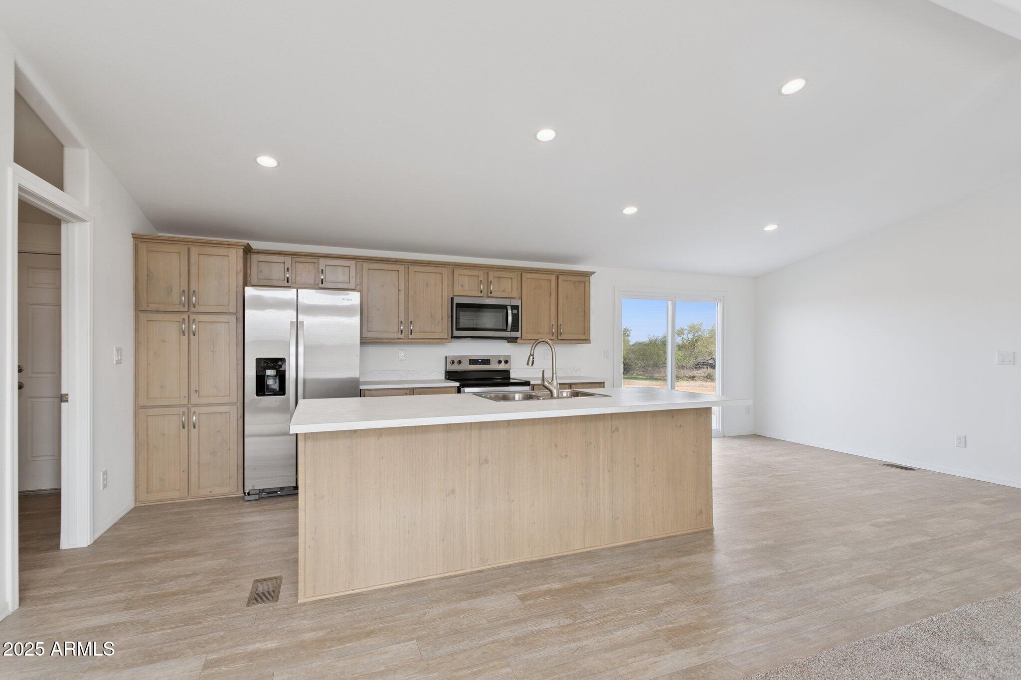 755 North Ralston Road Maricopa, AZ 85139 - Photo 15 of 34 a large kitchen with stainless steel appliances a large counter top and a stove