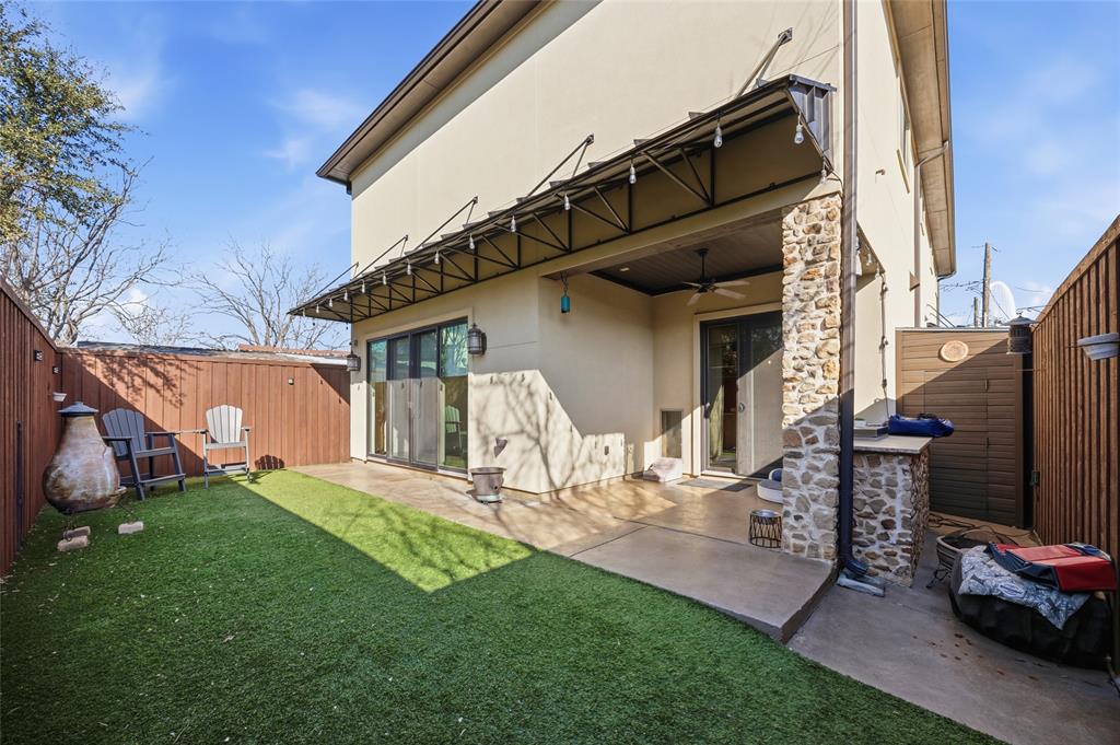 3105 Pastor Street Dallas, TX 75212 - Photo 8 of 28 Rear view of house with a fenced backyard, stucco siding, a patio area, and a ceiling fan with artifical turf.
