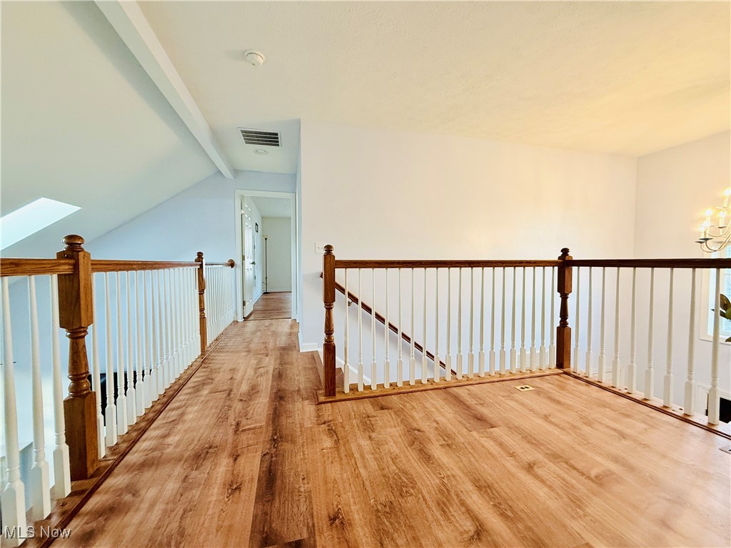 155 Stone Ridge Way Berea, OH 44017 - Photo 24 of 32 Hallway featuring wood finished floors, an upstairs landing, a chandelier, and a skylight