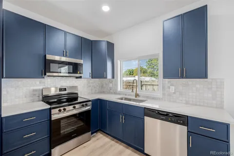 a kitchen with granite countertop wooden cabinets and a stove top oven