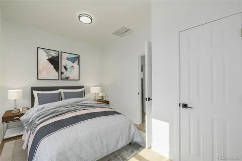 a bedroom with a bed and a painting on the wall