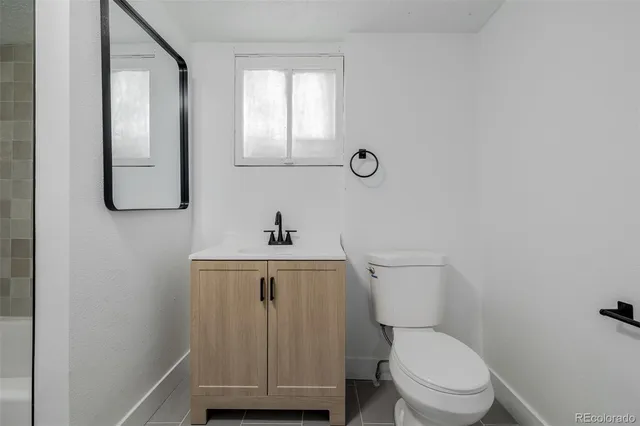 a bathroom with a toilet a sink and mirror