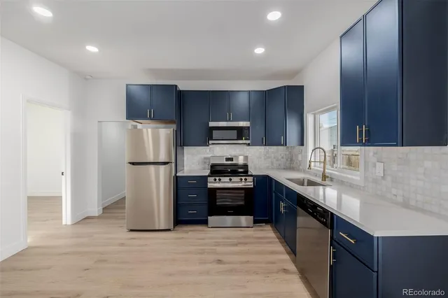 a kitchen with kitchen island a sink stainless steel appliances and cabinets