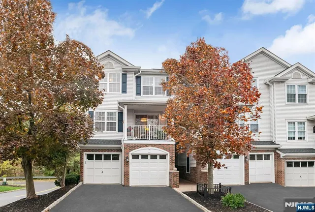 a view of a white building among the street with palm trees