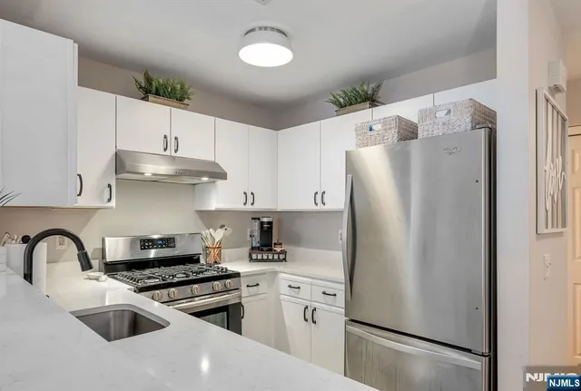 a kitchen with stainless steel appliances a refrigerator sink and cabinets