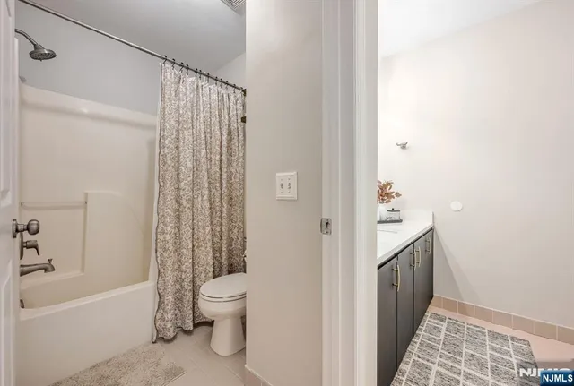 a bathroom with a sink a toilet and shower curtain