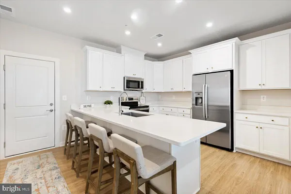 a kitchen with kitchen island a refrigerator stove microwave and cabinets