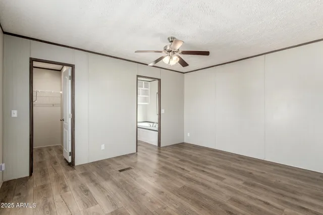 a kitchen with stainless steel appliances kitchen island granite countertop a stove a sink a refrigerator white cabinets and wooden floor