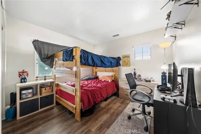a bedroom with a bed and wooden floor