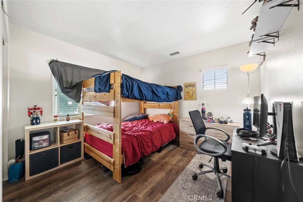 8055 Pueblo Place, Unit 101 Rancho Cucamonga, CA 91730 - Photo 13 of 30 a bedroom with a bed and wooden floor