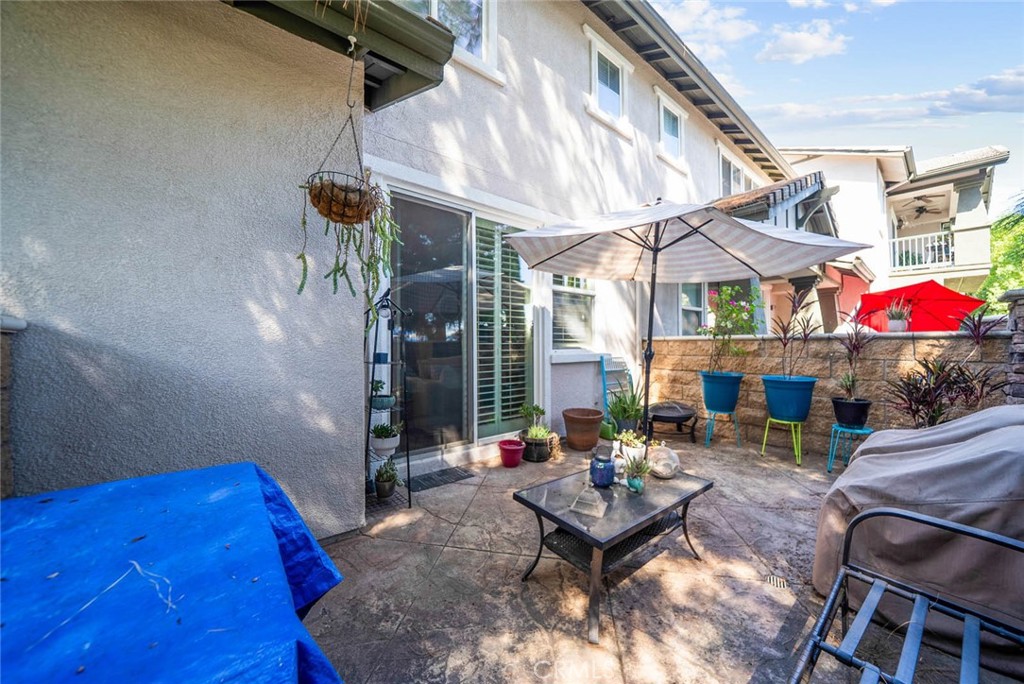 8055 Pueblo Place, Unit 101 Rancho Cucamonga, CA 91730 - Photo 20 of 30 a view of a patio with table and chairs and potted plants