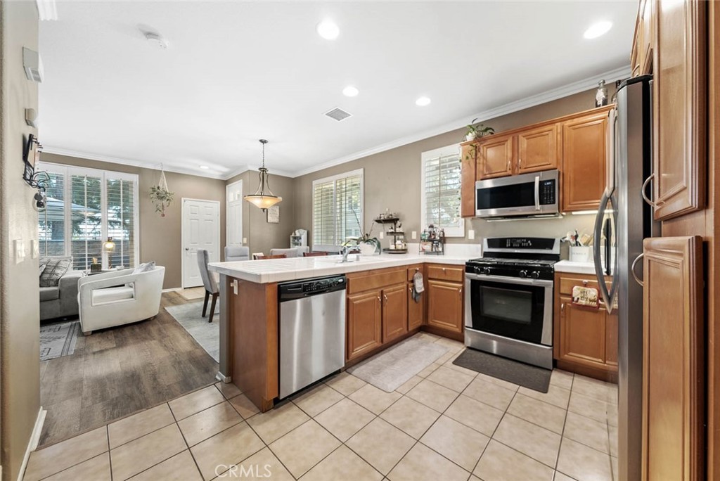 8055 Pueblo Place, Unit 101 Rancho Cucamonga, CA 91730 - Photo 4 of 30 a kitchen with stainless steel appliances a stove a sink and a refrigerator