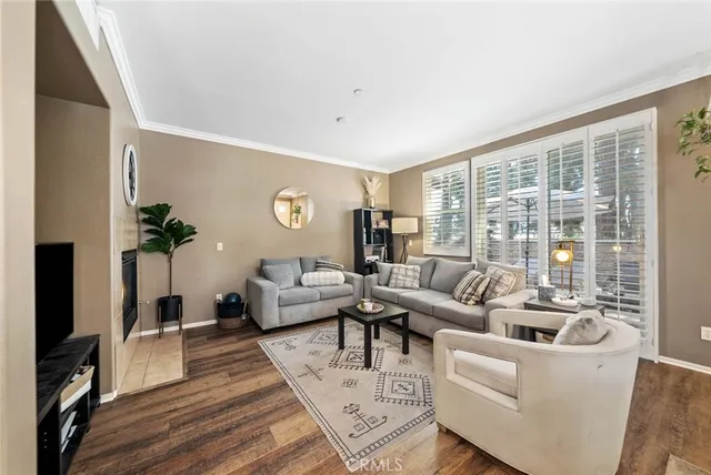 a living room with furniture large windows and wooden floor
