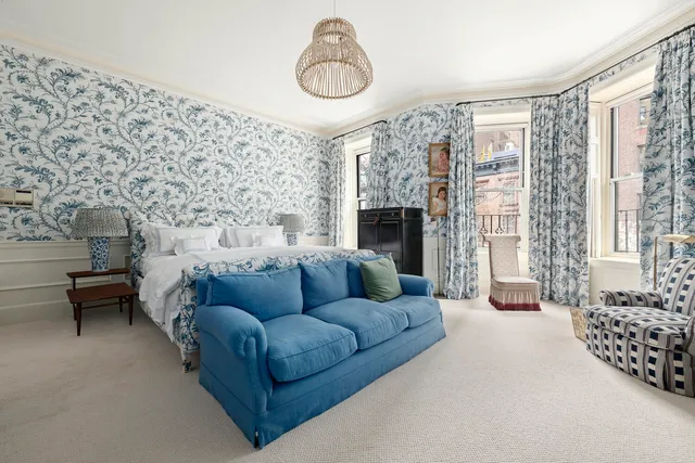 a bedroom with furniture and a large window