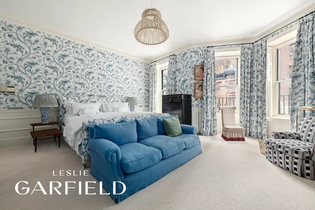 a bedroom with furniture and a large window