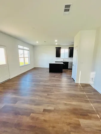 a view of empty room with wooden floor and window