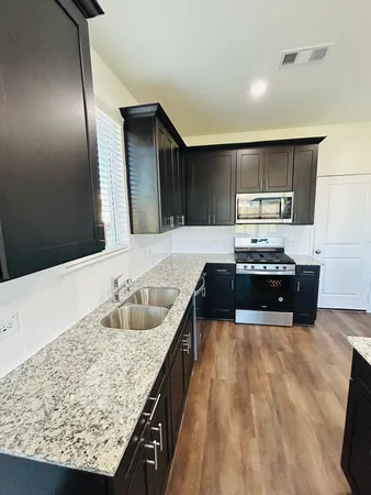 a kitchen with stainless steel appliances granite countertop a sink and a stove