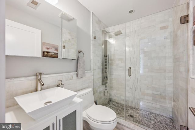 a bathroom with a sink toilet a mirror and shower