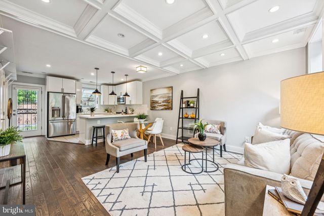 a living room with lots of furniture and kitchen view
