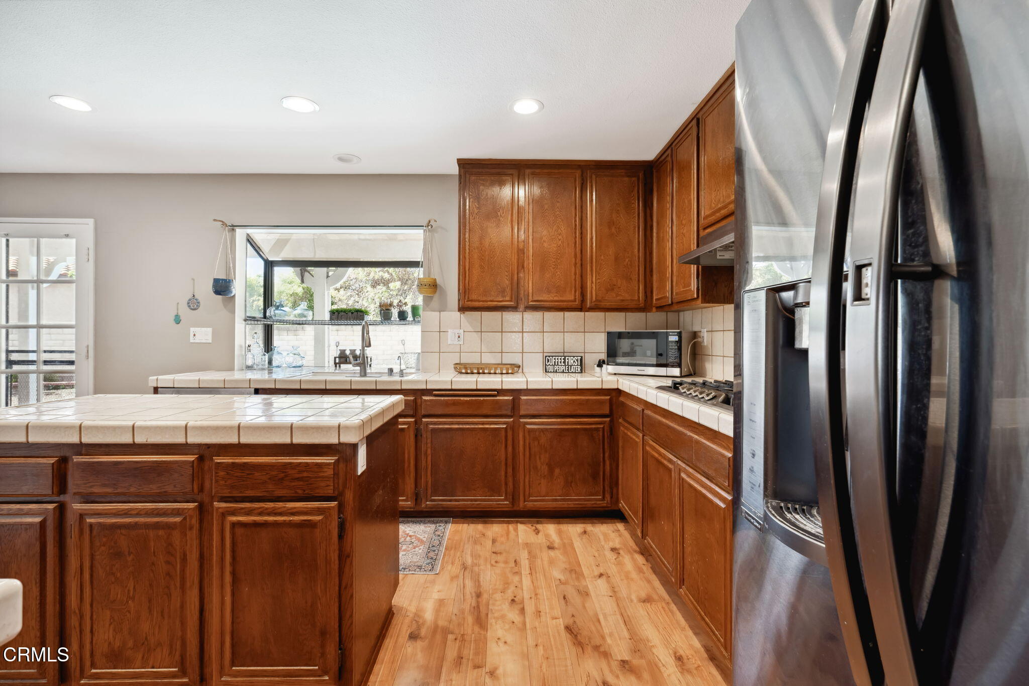 4293 Peach Slope Road Moorpark, CA 93021 - Photo 13 of 36 a kitchen with stainless steel appliances granite countertop a refrigerator a sink dishwasher a stove and white countertops with wooden floor