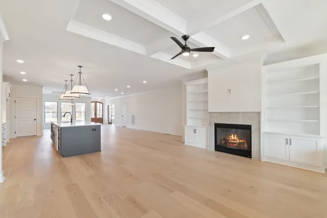 an open kitchen view with fireplace and wooden floor