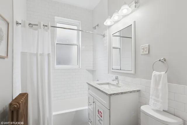 a bathroom with a granite countertop sink a toilet and shower