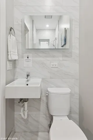a bathroom with a sink a toilet and mirror