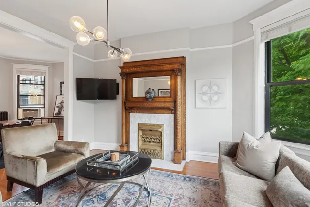 a living room with furniture a flat screen tv and a fireplace