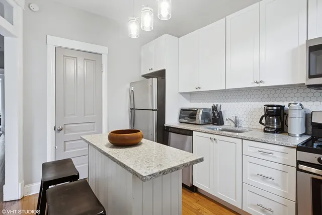 a kitchen with stainless steel appliances a stove refrigerator and cabinets