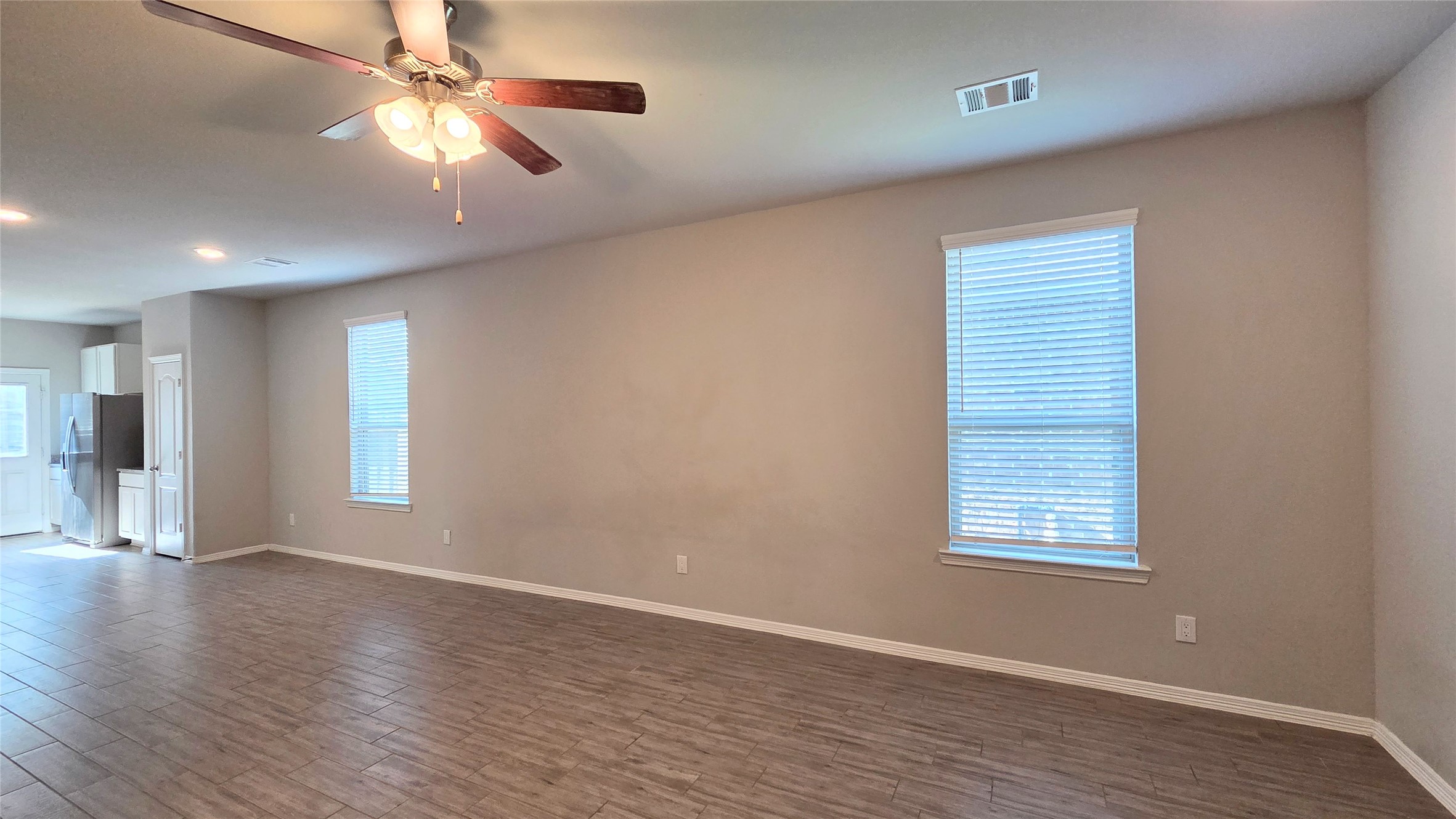 914 Redinger Ridge Drive Houston, TX 77336 - Photo 6 of 16 an empty room with wooden floor chandelier fan and windows
