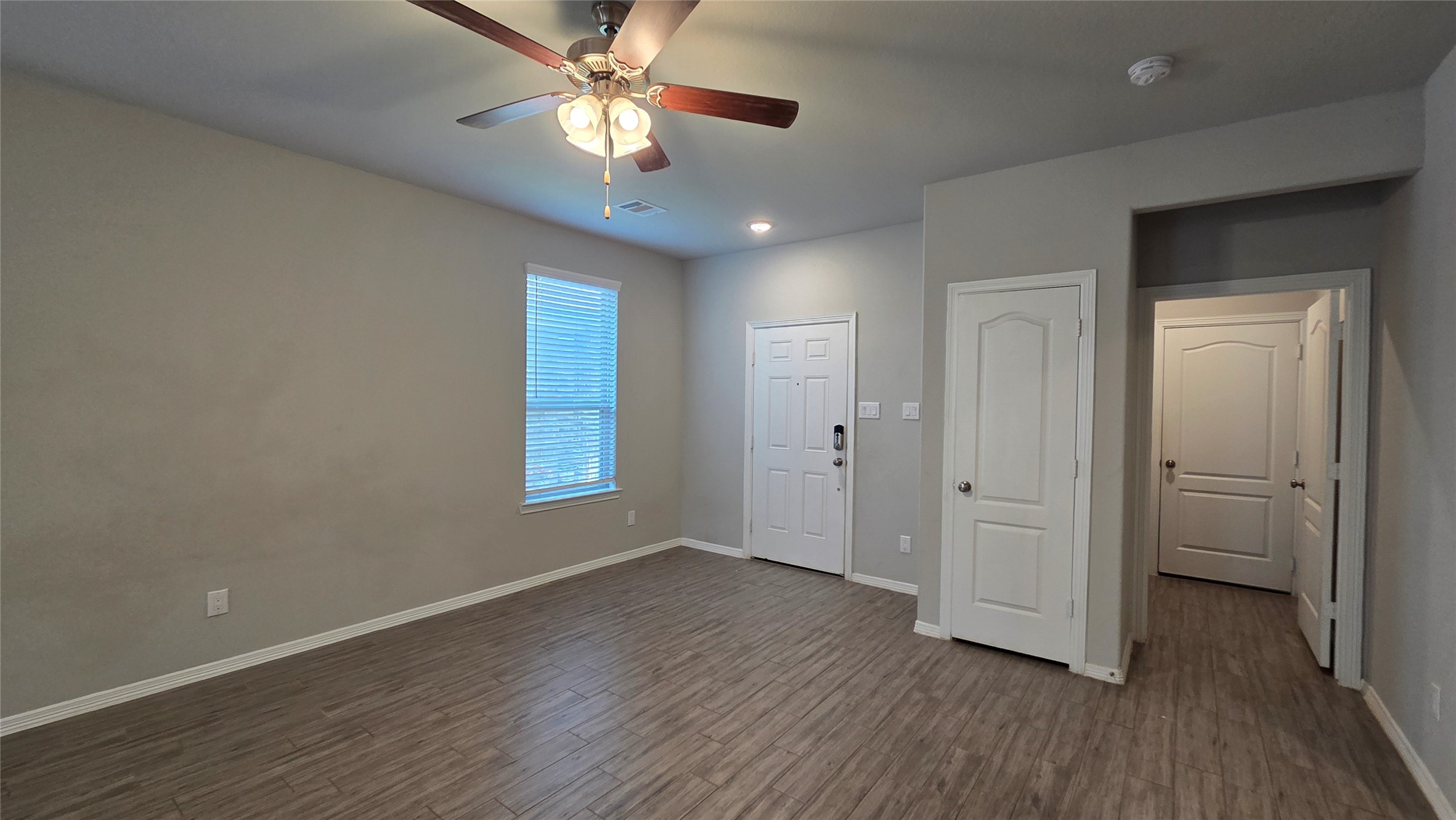 914 Redinger Ridge Drive Houston, TX 77336 - Photo 7 of 16 a view of an empty room with wooden floor and a ceiling fan