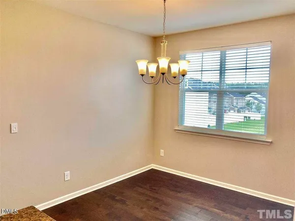 a view of a room with a large window and wooden floor