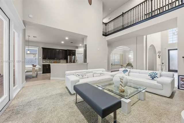 a living room with furniture a view of kitchen and a dining table