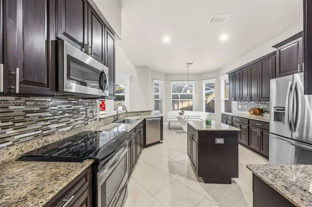 a kitchen with granite countertop stainless steel appliances and wooden cabinets