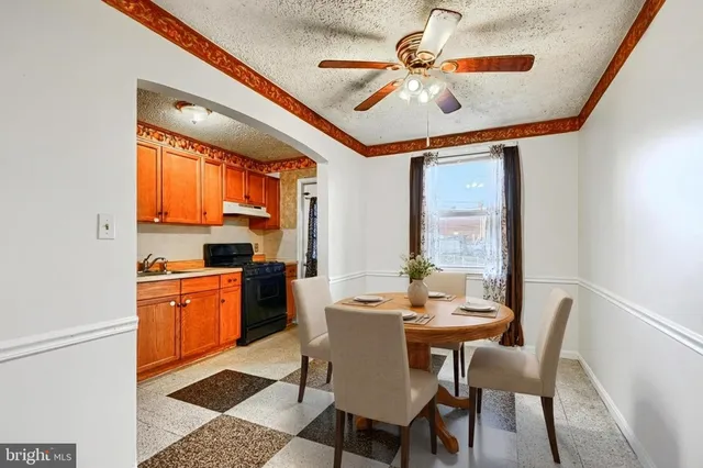 a dining room with stainless steel appliances kitchen island granite countertop furniture and a large window