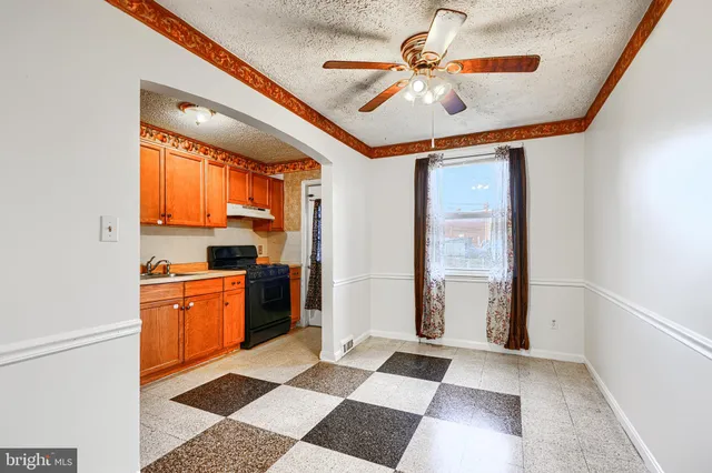 a large white kitchen with stainless steel appliances granite countertop a refrigerator and a sink