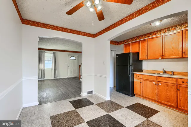 a kitchen with stainless steel appliances granite countertop a refrigerator a stove and white cabinets with wooden floor