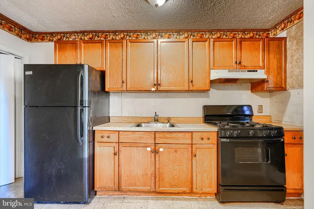 a kitchen with stainless steel appliances granite countertop a refrigerator and a stove