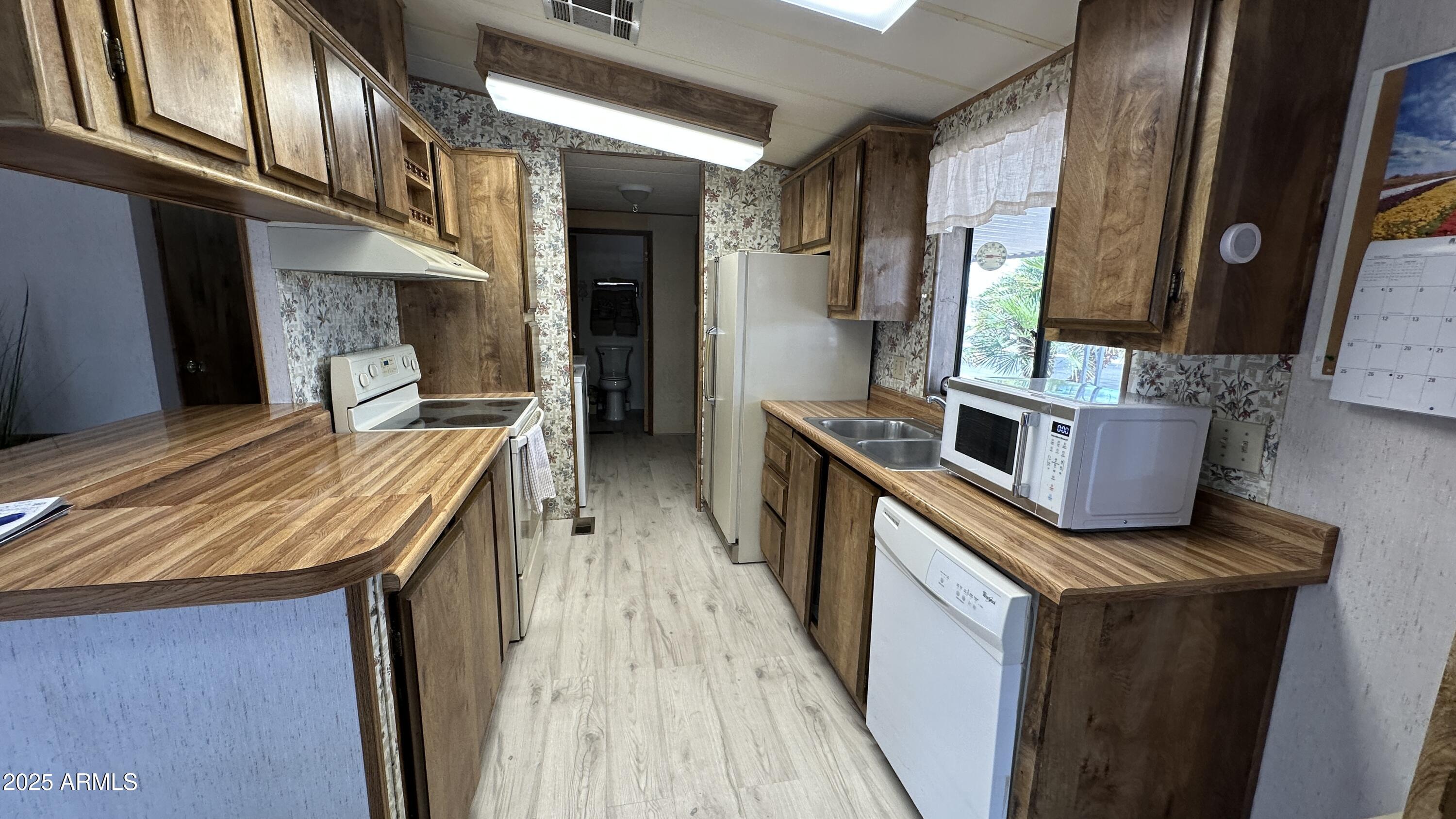 834 South Meridian Road, Unit 124 Apache Junction, AZ 85120 - Photo 16 of 28 a kitchen with stainless steel appliances granite countertop a stove and a refrigerator