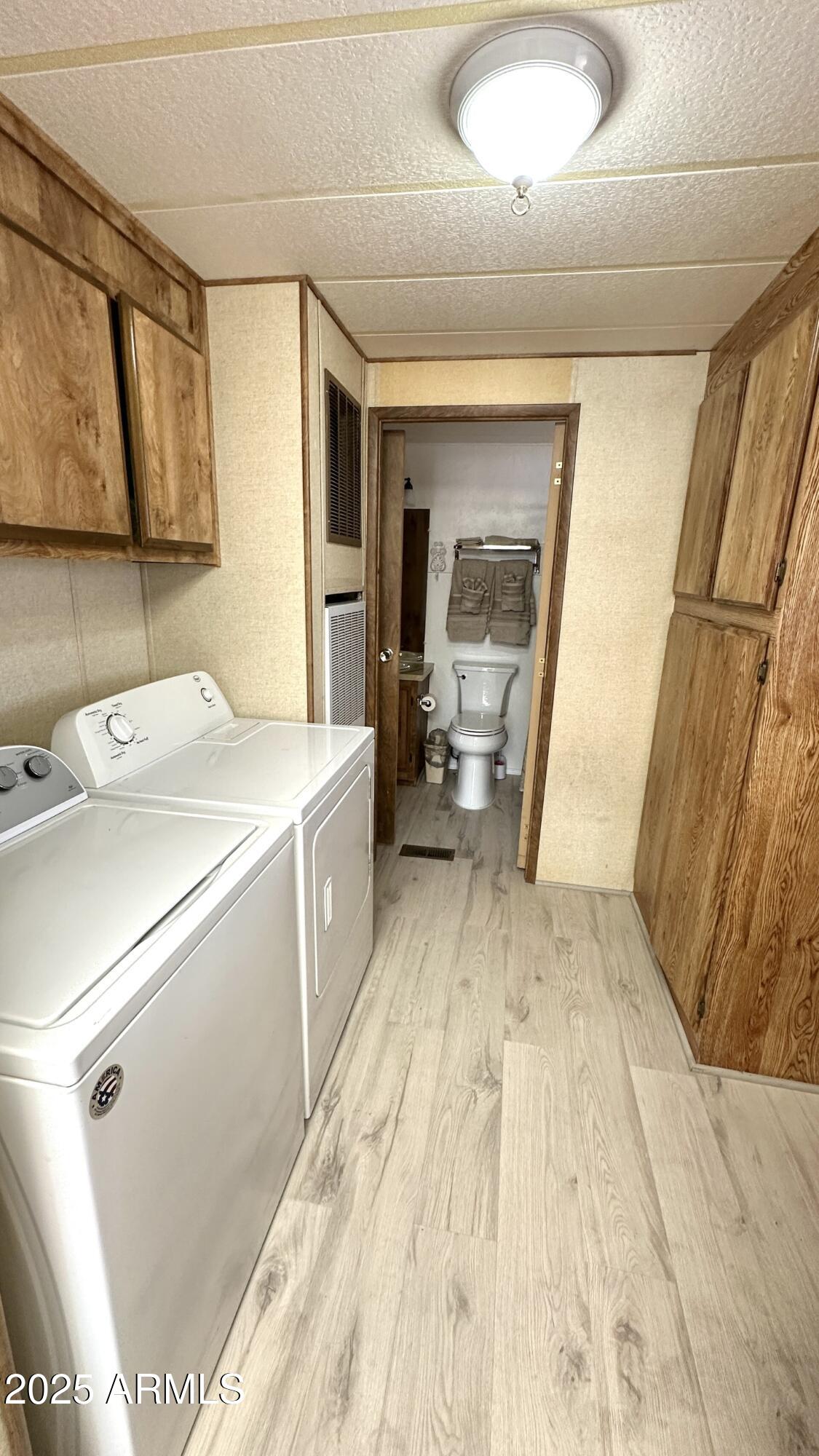 834 South Meridian Road, Unit 124 Apache Junction, AZ 85120 - Photo 19 of 28 a view of washer and dryer with kitchen in the background